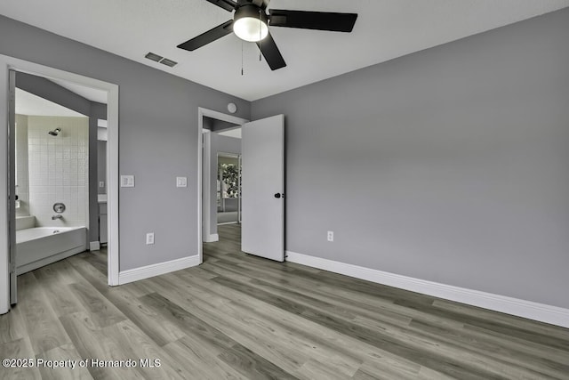 13406 Banyan Rd, Spring Hill, FL 34609 - unfurnished bedroom with wood finished floors, baseboards, ceiling fan, and connected bathroom