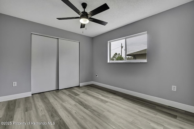 13406 Banyan Rd, Spring Hill, FL 34609 - unfurnished bedroom with wood finished floors, baseboards, a closet, and a ceiling fan