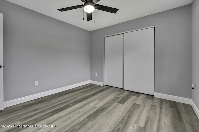 13406 Banyan Rd, Spring Hill, FL 34609 - unfurnished bedroom with wood finished floors, baseboards, a closet, and a ceiling fan