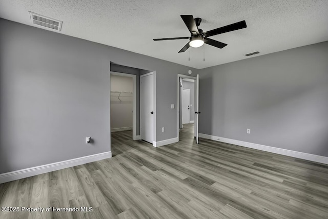 13406 Banyan Rd, Spring Hill, FL 34609 - unfurnished bedroom featuring a textured ceiling, baseboards, wood finished floors, a closet, and a ceiling fan