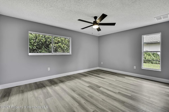 13406 Banyan Rd, Spring Hill, FL 34609 - empty room with a textured ceiling, a ceiling fan, wood finished floors, and baseboards