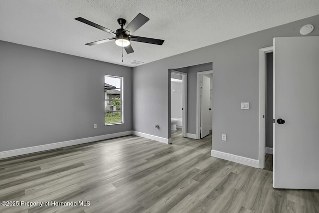 13406 Banyan Rd, Spring Hill, FL 34609 - unfurnished bedroom with a textured ceiling, wood finished floors, baseboards, ensuite bathroom, and a ceiling fan