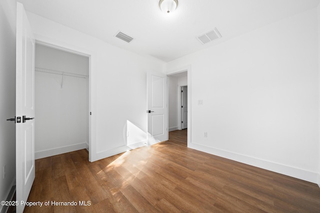 14376 Earline Ave, Weeki Wachee, FL 34614 - unfurnished bedroom with wood finished floors, baseboards, and a closet