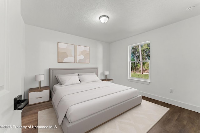 14376 Earline Ave, Weeki Wachee, FL 34614 - bedroom with wood finished floors, a textured ceiling, and baseboards