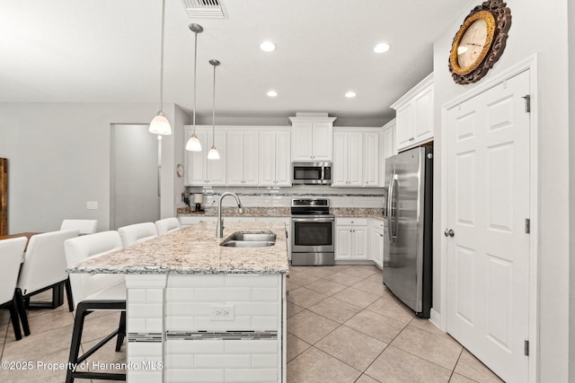18620 Rococo Rd, Spring Hill Pasco, FL 34610 - kitchen with stainless steel appliances, a sink, light tile patterned floors, a kitchen breakfast bar, and white cabinets