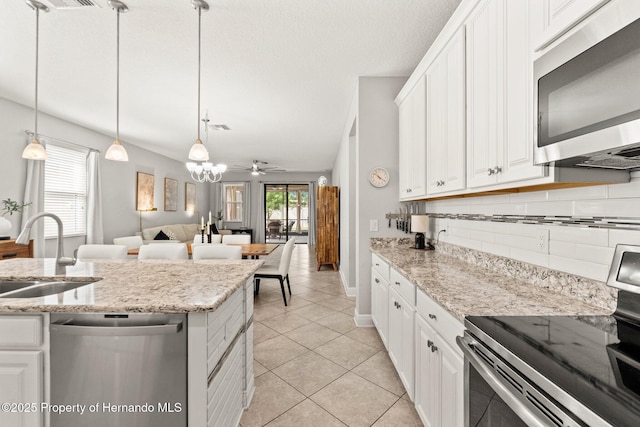 18620 Rococo Rd, Spring Hill Pasco, FL 34610 - kitchen with appliances with stainless steel finishes, a sink, backsplash, light tile patterned floors, and white cabinets