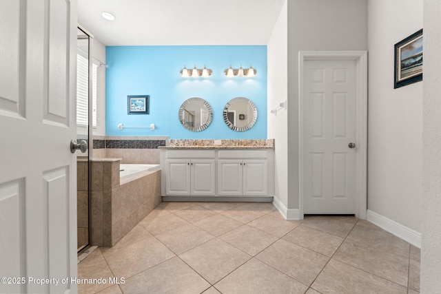 18620 Rococo Rd, Spring Hill Pasco, FL 34610 - bathroom featuring a garden tub, double vanity, tile patterned floors, and baseboards
