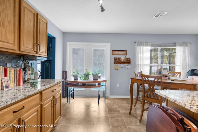 10457 Cranston St, Spring Hill, FL 34608 - kitchen featuring light stone counters, light tile patterned floors, and baseboards