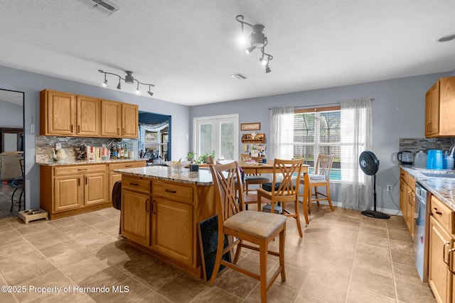 10457 Cranston St, Spring Hill, FL 34608 - kitchen with decorative backsplash, plenty of natural light, and light stone counters