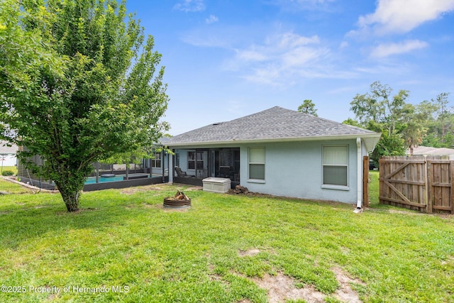 10457 Cranston St, Spring Hill, FL 34608 - rear view of house featuring a sunroom, roof with shingles, stucco siding, and a fire pit