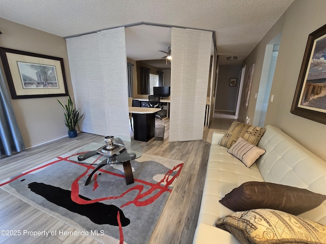 2429 Birdie Ln, Spring Hill, FL 34606 - living area featuring wood finished floors, a textured ceiling, and a ceiling fan
