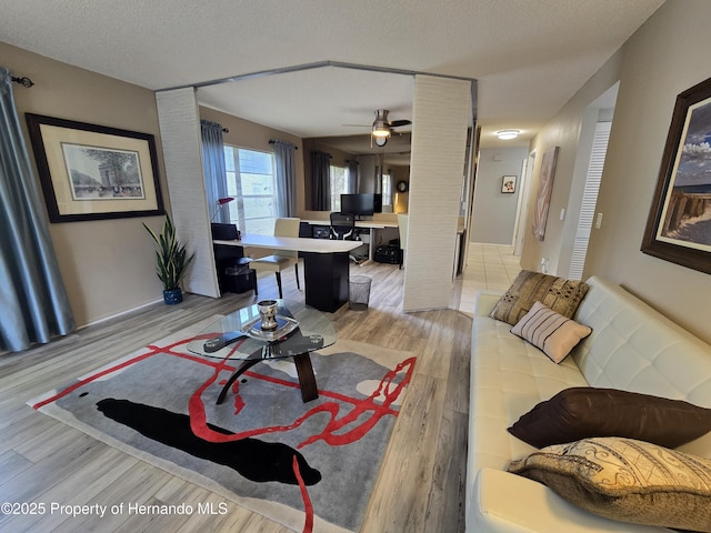2429 Birdie Ln, Spring Hill, FL 34606 - living room featuring light wood-type flooring, a ceiling fan, and a textured ceiling