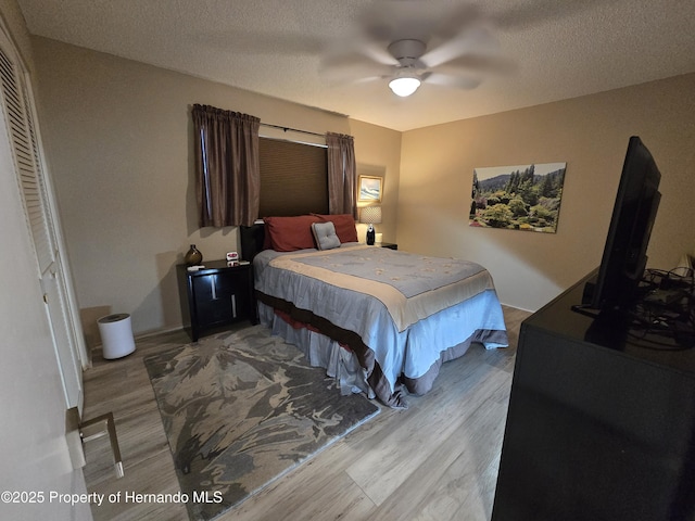 2429 Birdie Ln, Spring Hill, FL 34606 - bedroom featuring wood finished floors, a ceiling fan, and a textured ceiling