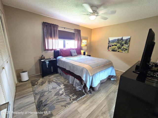 2429 Birdie Ln, Spring Hill, FL 34606 - bedroom featuring wood finished floors, a textured ceiling, and a ceiling fan