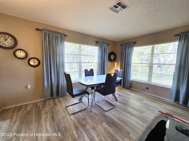 2429 Birdie Ln, Spring Hill, FL 34606 - dining room with a textured ceiling and wood finished floors