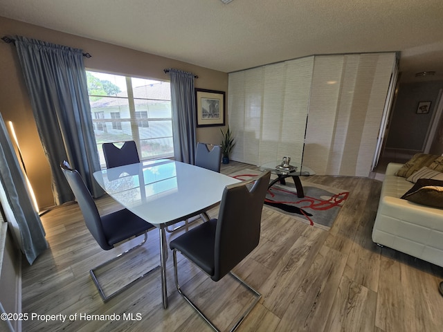 2429 Birdie Ln, Spring Hill, FL 34606 - dining space with light wood finished floors and a textured ceiling