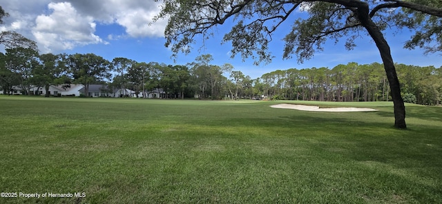2429 Birdie Ln, Spring Hill, FL 34606 - surrounding community with golf course view, a lawn, and view of scattered trees