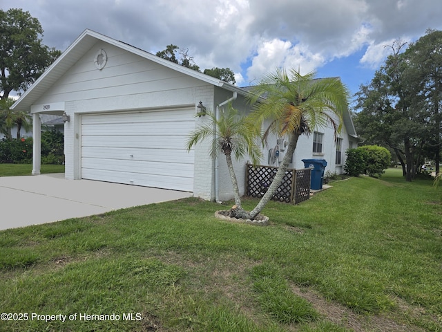 2429 Birdie Ln, Spring Hill, FL 34606 - view of side of home featuring driveway, an attached garage, a lawn, and brick siding