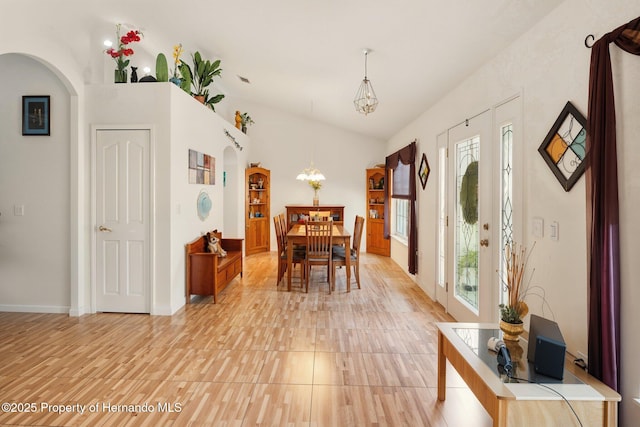 15348 Glossy Ibis Rd, Brooksville, FL 34614 - dining area with arched walkways, a chandelier, lofted ceiling, and baseboards
