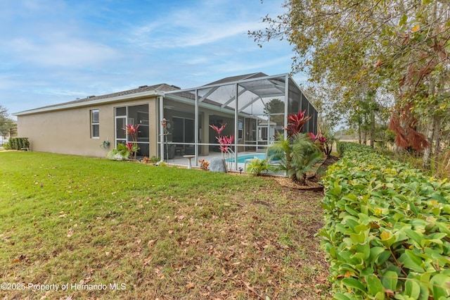 17679 Garsalaso Cir, Brooksville, FL 34604 - rear view of property featuring stucco siding, a yard, an outdoor pool, and glass enclosure