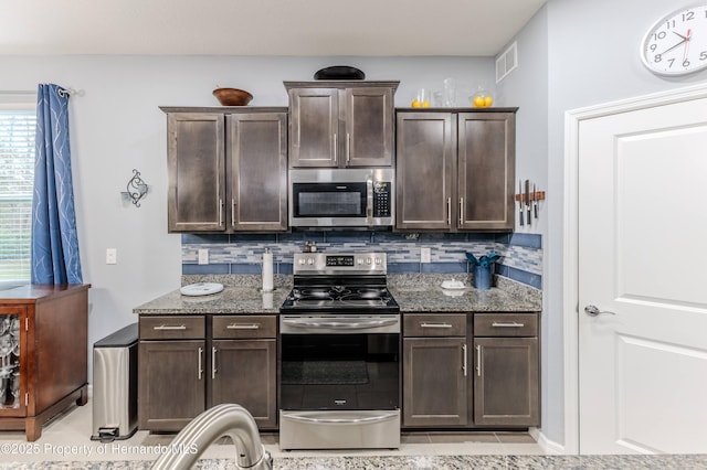 17679 Garsalaso Cir, Brooksville, FL 34604 - kitchen featuring stainless steel appliances, dark brown cabinets, stone counters, backsplash, and light tile patterned flooring