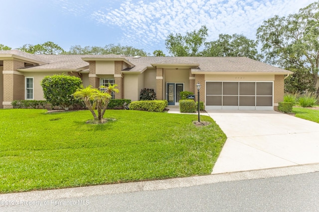 2481 Whispering Pines Ct, Spring Hill, FL 34606 - view of front of property with a garage, driveway, a front lawn, and brick siding