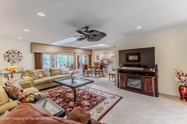 2481 Whispering Pines Ct, Spring Hill, FL 34606 - living room featuring ceiling fan, a textured ceiling, light tile patterned flooring, a skylight, and recessed lighting