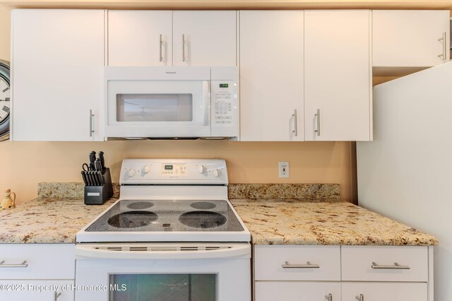 2481 Whispering Pines Ct, Spring Hill, FL 34606 - kitchen featuring white appliances, white cabinets, and light stone countertops