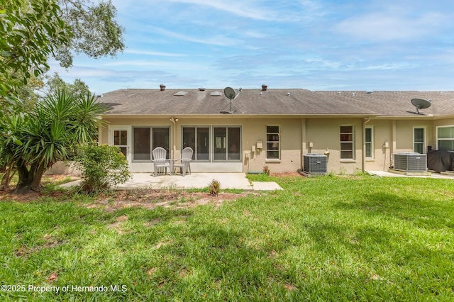 2481 Whispering Pines Ct, Spring Hill, FL 34606 - rear view of property with central air condition unit, stucco siding, a lawn, and a sunroom