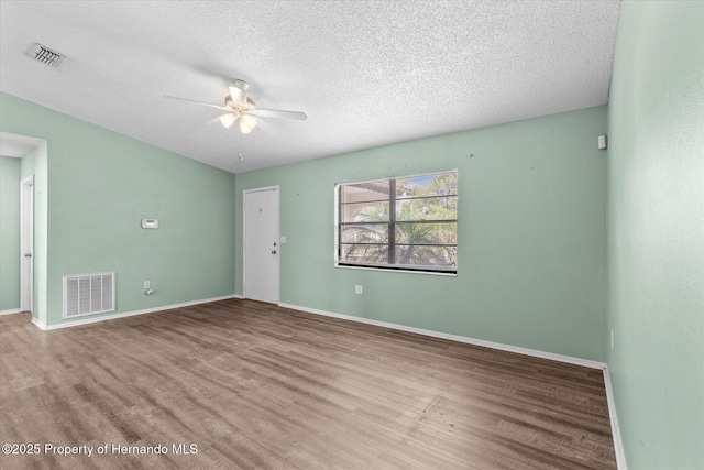 2450 Ambassador Ave, Spring Hill, FL 34609 - empty room featuring a ceiling fan, wood finished floors, a textured ceiling, and baseboards