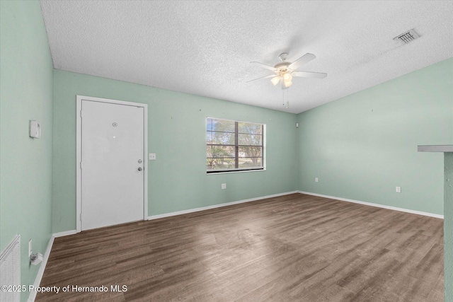 2450 Ambassador Ave, Spring Hill, FL 34609 - empty room featuring a ceiling fan, a textured ceiling, wood finished floors, and baseboards