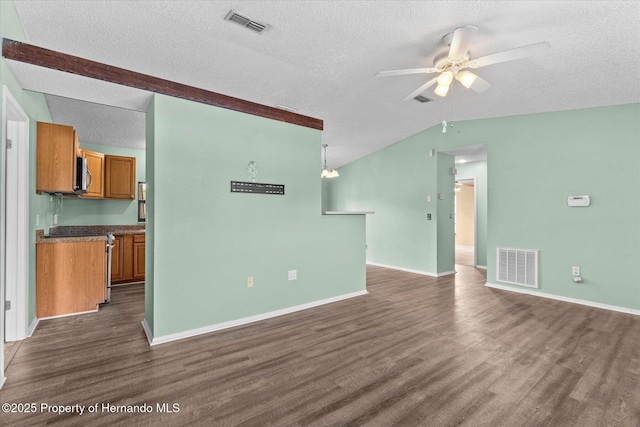 2450 Ambassador Ave, Spring Hill, FL 34609 - unfurnished living room featuring vaulted ceiling, dark wood-type flooring, ceiling fan, a textured ceiling, and baseboards
