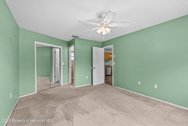 2450 Ambassador Ave, Spring Hill, FL 34609 - unfurnished bedroom featuring carpet floors, a closet, a textured ceiling, baseboards, and a ceiling fan