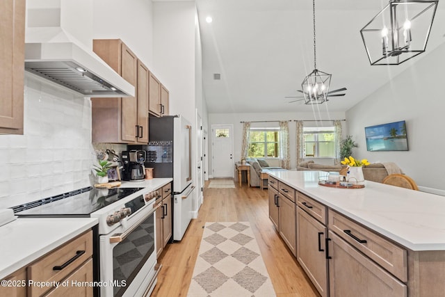 27295 Tarbel Rd, Brooksville, FL 34602 - kitchen with white range with electric cooktop, wall chimney range hood, a chandelier, open floor plan, and lofted ceiling