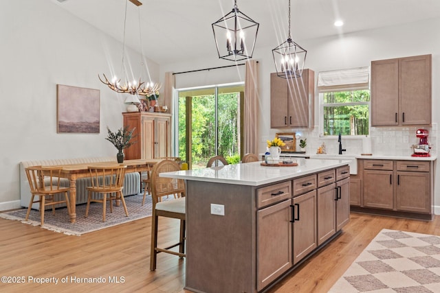 27295 Tarbel Rd, Brooksville, FL 34602 - kitchen with a chandelier, a sink, light countertops, light wood-style flooring, and recessed lighting