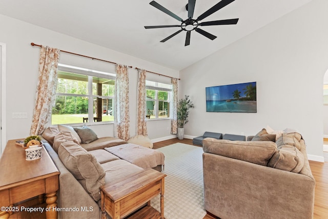 27295 Tarbel Rd, Brooksville, FL 34602 - living room with wood finished floors, baseboards, lofted ceiling, ceiling fan, and arched walkways