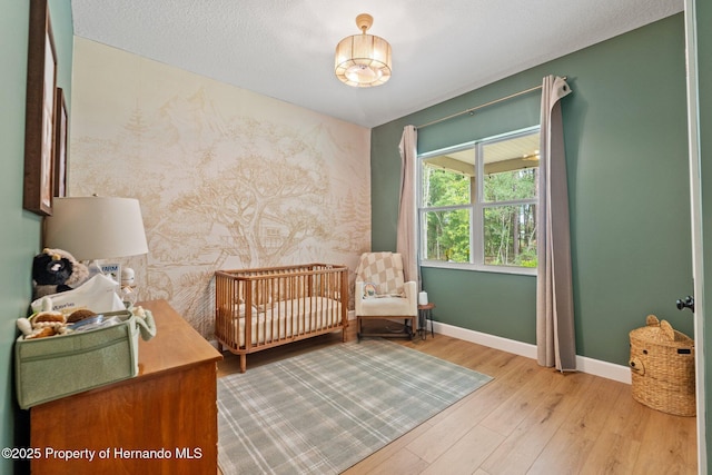 27295 Tarbel Rd, Brooksville, FL 34602 - bedroom featuring wood finished floors, baseboards, and a crib