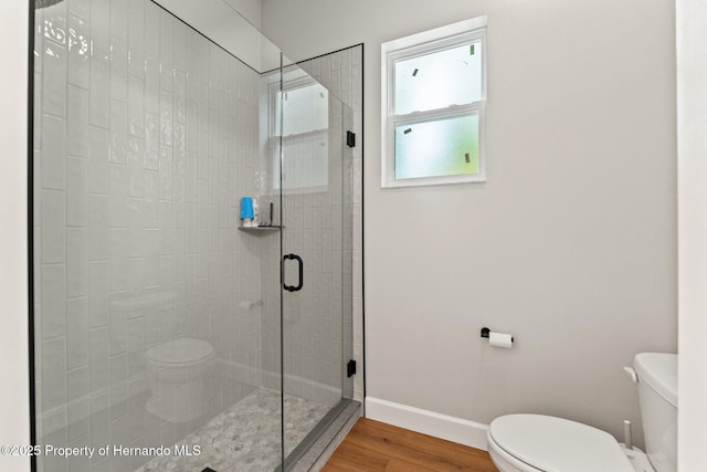27295 Tarbel Rd, Brooksville, FL 34602 - bathroom featuring toilet, wood finished floors, a stall shower, and baseboards