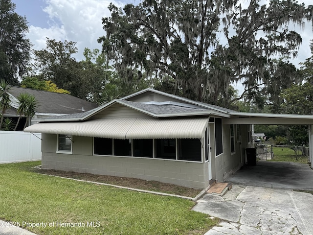 221 Highland St, Brooksville, FL 34601 - view of home's exterior with concrete block siding, a shingled roof, concrete driveway, and a carport