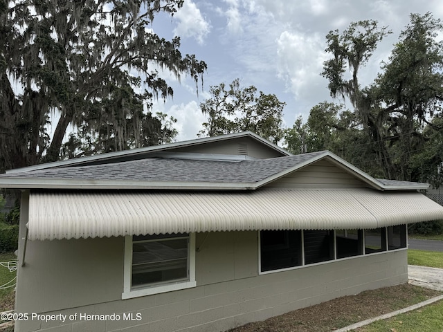 221 Highland St, Brooksville, FL 34601 - view of property exterior featuring a shingled roof and concrete block siding