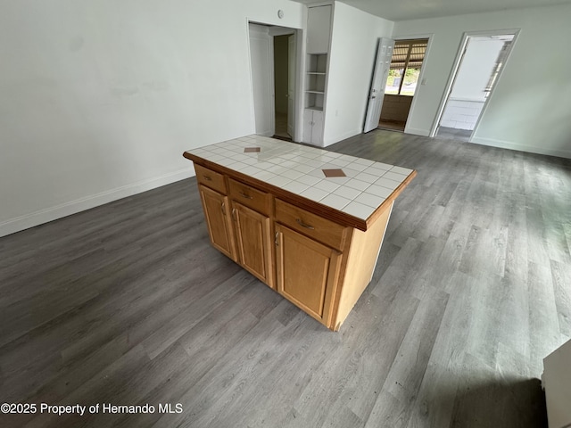 221 Highland St, Brooksville, FL 34601 - kitchen featuring tile counters, dark wood-style flooring, baseboards, brown cabinetry, and open floor plan