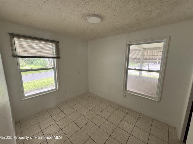 221 Highland St, Brooksville, FL 34601 - spare room with a textured ceiling, baseboards, and light tile patterned floors