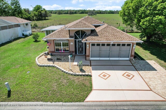 10485 S Drew Bryant Cir, Floral City, FL 34436 - view of front of house featuring roof with shingles, driveway, a garage, a front yard, and stucco siding