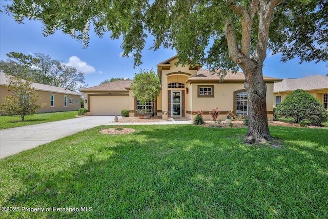 9406 Burnam Dr, Weeki Wachee, FL 34613 - mediterranean / spanish home featuring stucco siding, an attached garage, driveway, and a front lawn
