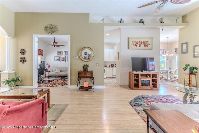 9406 Burnam Dr, Weeki Wachee, FL 34613 - living area with a ceiling fan, light wood-style flooring, ornate columns, a chandelier, and baseboards
