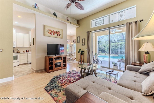 9406 Burnam Dr, Weeki Wachee, FL 34613 - living room with a ceiling fan, light wood-style floors, baseboards, a high ceiling, and recessed lighting