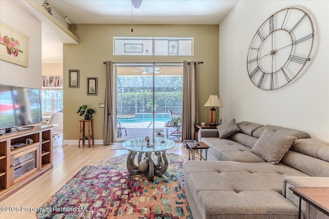 9406 Burnam Dr, Weeki Wachee, FL 34613 - living area with light wood-type flooring, healthy amount of natural light, baseboards, and a high ceiling