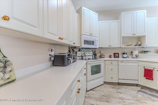 9406 Burnam Dr, Weeki Wachee, FL 34613 - kitchen featuring white appliances, white cabinetry, light countertops, open shelves, and light marble finish floors