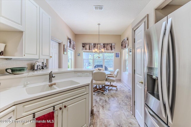9406 Burnam Dr, Weeki Wachee, FL 34613 - kitchen with stainless steel refrigerator with ice dispenser, a chandelier, light marble finish floors, a sink, and pendant lighting