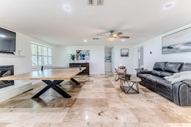 4566 Gulfstream Dr, Hernando Beach, FL 34607 - living room with a textured ceiling, a fireplace, a ceiling fan, recessed lighting, and baseboards
